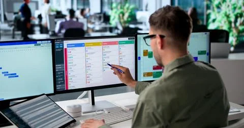 Agile Project Manager Updates Digital Scrum Board Tasks Using Laptop Screen. Stock Photos