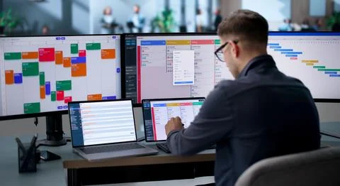 Agile Project Manager Updates Scrum Board And Checks Laptop Tasks. Stock Photos
