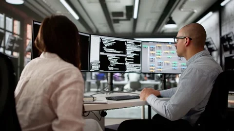 Agile Software Developers Using Multiple Screens Stock Footage 309308001