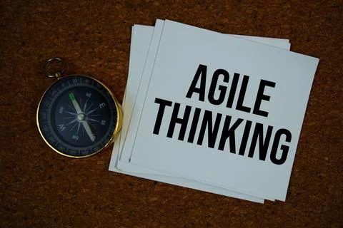 Agile Thinking text on paper card with compass on cork paper background Stock Photos