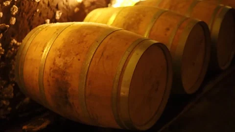 Aging wine barrels in dimly lit cellar, cinematic footage showing rows of w.. 動画素材 334327129