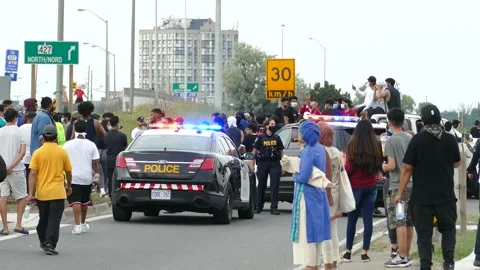 Agitated protesters are all but calm while surrounding a single police vehicle Stock Footage 133975495