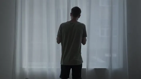 Agoraphobic man staring out the window, afraid to leave home. Mental health Stock Footage 311020102