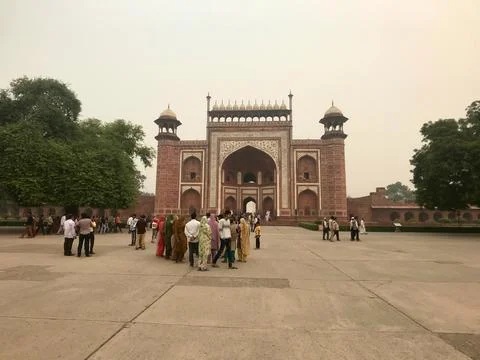 Agra, India, November 2019 - A group of people walking outside of a building Fotos de archivo