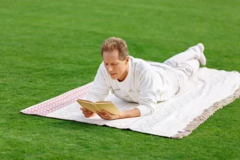 Agreeable man lying on the grass Stock Photos