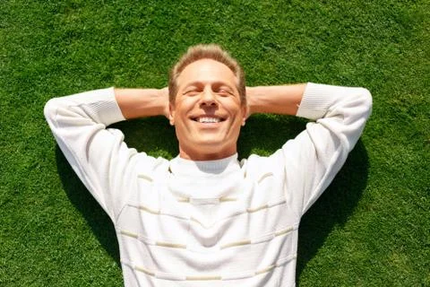 Agreeable man lying on the grass Stock Photos