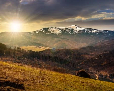 Agricultural field with haystack on hillside at sunset Stock Photos
