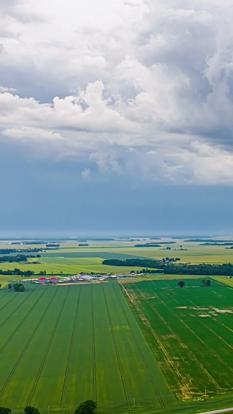 Agricultural Fields with Parallel Lines Beneath Dramatic Cloudy Sky Stock Footage 342786300