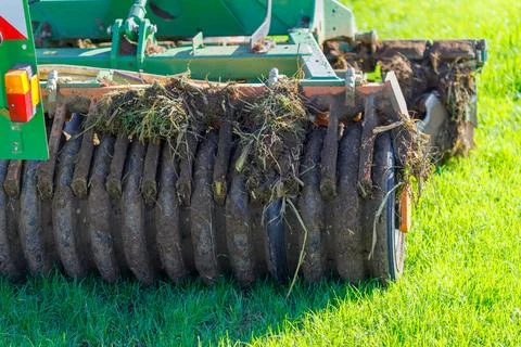Agricultural Implement with Mud-Covered Discs in Green Field Stock Photos