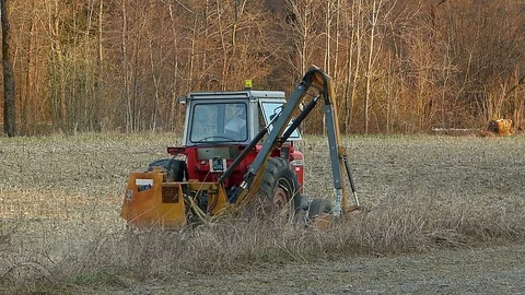 Agricultural labor.  Tractor with shredder to work the field border . Stock Footage 73835758