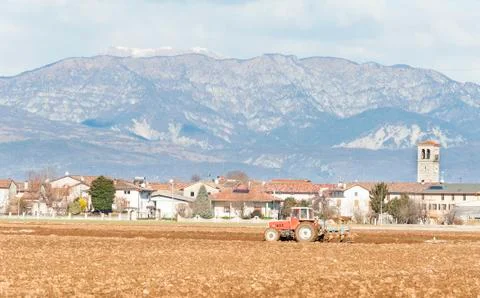 Agricultural landscape with tractor plowing. Stock Photos