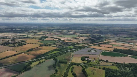 Agricultural Patchwork Landscape Captured Under Dramatic Cloudscape Stock Footage 312802968