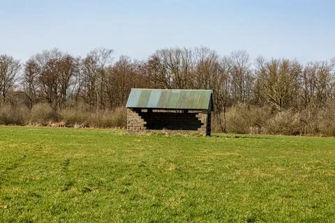 Agricultural plot with small shed with a huge hole in the wall Stock Photos