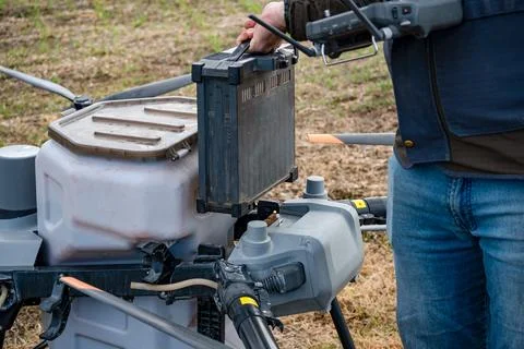 Agricultural technicians replace the battery of a large agricultural drone... Foto stock