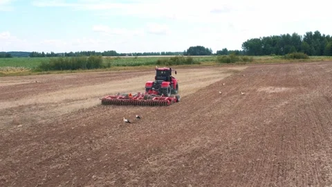 Agricultural Tractor With Harrow System Plowing Ground On Cultivated Farm Field Stock Footage 269118893