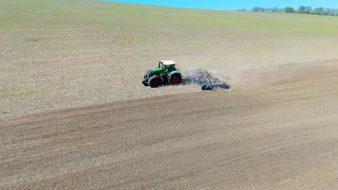 Agricultural tractor performing field work, showcasing a dynamic sequence of Video stock 318712976