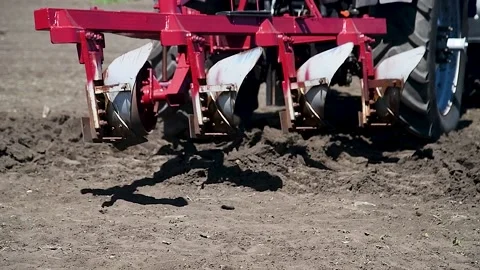 Agricultural tractor plowing a field Видео 223687733