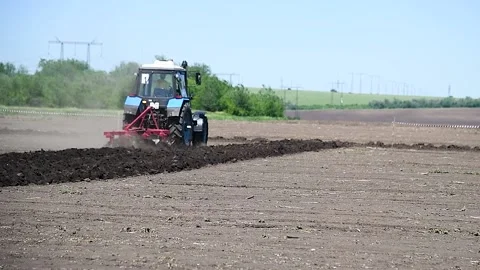 Agricultural tractor plowing a field Stockbeeldmateriaal 225324328