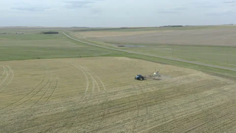 Agricultural tractor pulling seeding machine, aerial sideways panning Stock Footage 157476686