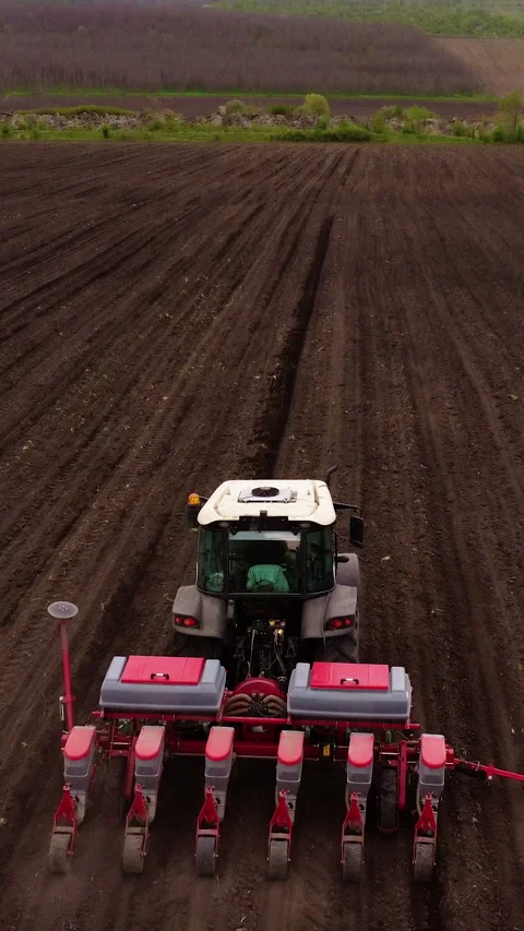 Agricultural tractor with seed planter efficiently cultivates soil in a field Stock Footage 325201706