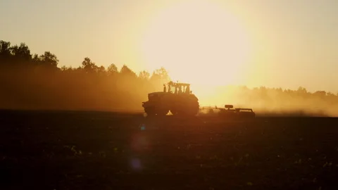 Agricultural Tractor Working on Field at Sunset During Spring Seeding Vídeo Stock 345021384