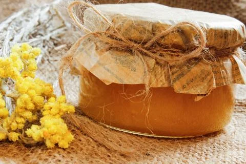 Agriculture. bank with honey with yellow dry flowers on burlap. Side view Stock Photos