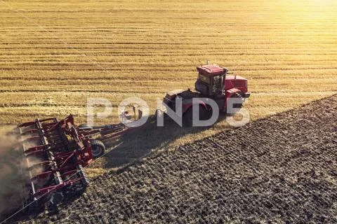 Agriculture machine harvesting crop in fields. Tractor pulls a mechanism for Stock Photos