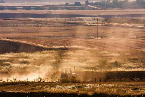 Agriculture tractor working dry fields in Ciudad Real at sunset Stock Photos
