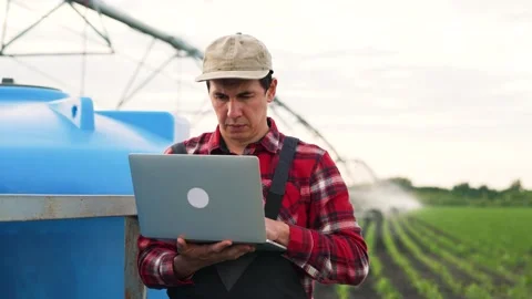 Agriculture.Farmer engineer is work with laptop in field.Automatic irrigation Stock Footage 255239621