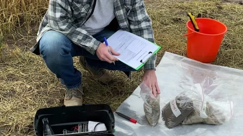 Agriculturist taking notes to soil sampling information sheet at field Stock Footage 201595358