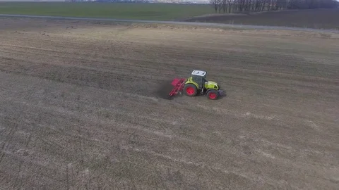 Agrobusiness - field work in early spring. Tractor cultivates the land on the Stock Footage 74337427