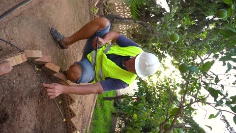 Agronomist engineer checks irrigation pipe of a garden, controls irrigation w Stock Footage 219506233