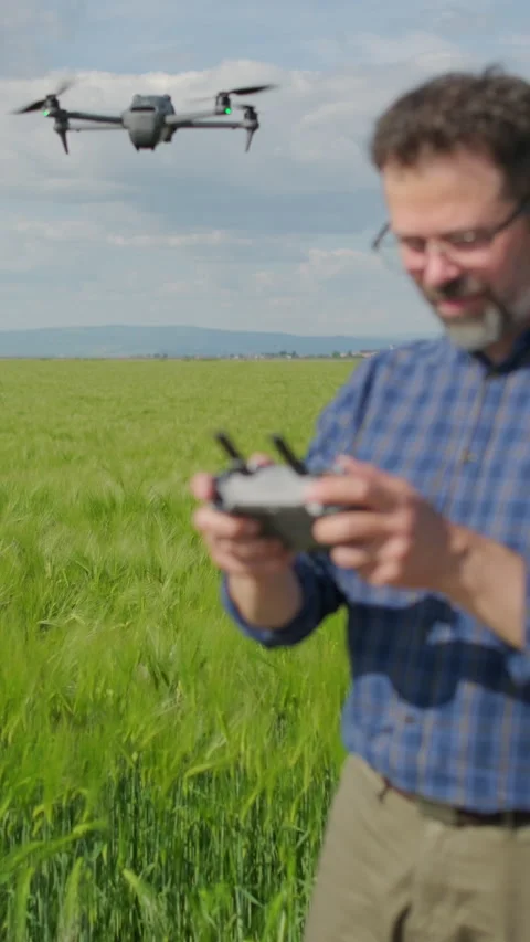 Agronomist holding drone controller with hovering UAV in background Stock Footage 337120964