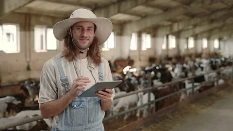 Agronomist using digital tablet while standing at goat farm Stock Footage 157579954
