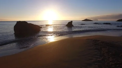 Aguas blancas, ibiza sunrise low over gentle waves between rocks Stock Footage 87872296