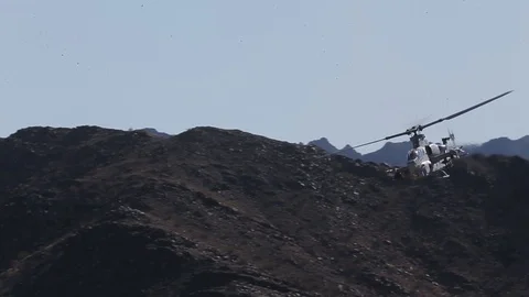 AH-1 Cobra helicopter flying through mountains Stock Footage 106928668