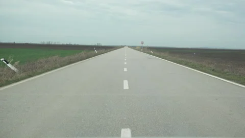 Ahead view low angle car drive on long straight empty road Stock Footage 318179635