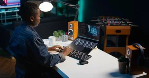 AI expert writes code on laptop in apartment office Stockfoto's