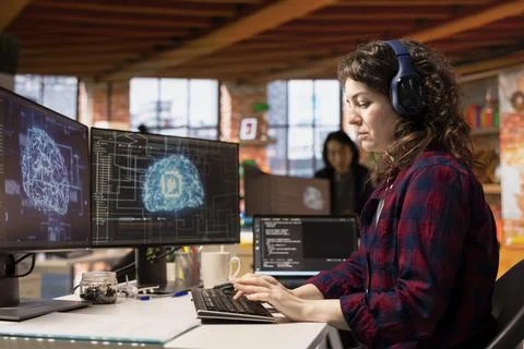 AI industry startup technician coding and listening music in office Stock Photos