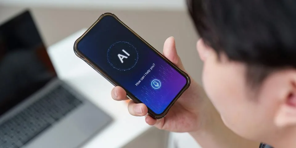 AI Interaction. Young man using smartphone with AI assistant. Stock Photos