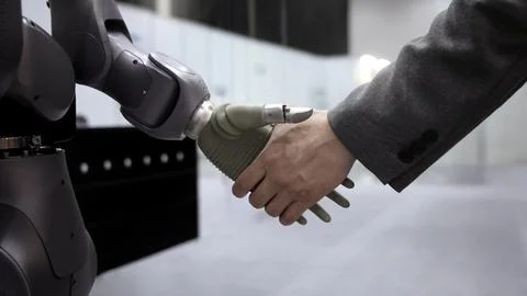 AI Robot shaking hands with man. Close up shaking hand with robotic arm Stock Photos