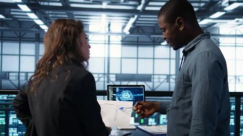 AI server room admins looking over financial documents, using tablet Stock Photos