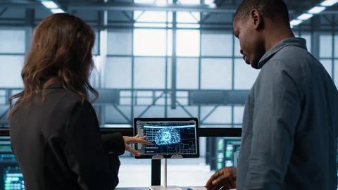 AI server room admins looking over financial documents, using tablet Foto stock