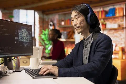 AI startup office senior developer listening music while building application 스톡 사진