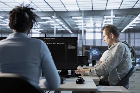 AI technician at work in high tech server room analyzing data on monitors 스톡 사진