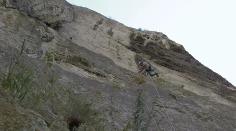 Aid climber placing piton for protection Stock Footage 25915518