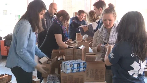 Aid workers in Toronto packaging supplies for victims in war ravaged Syria Stock Footage 73720805
