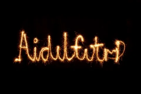 Aidilfitri written with sparkle fire alphabet Stock Photos