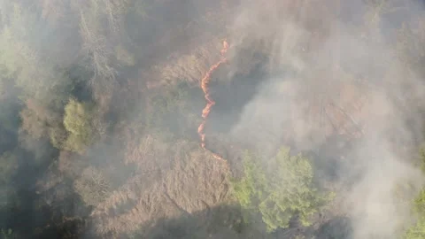 Aieral view of fire spreading on a mountain forest bank from kids starting fires Stock Footage 153052694