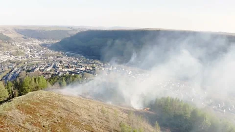 Aieral view of fire spreading on a mountain forest bank from kids starting fires Stock Footage 153053206